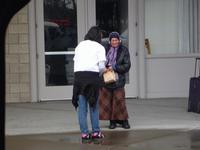 Athena handing out a bag lunch to a homeless lady