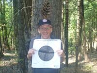 Just see if you can shoot the pine cone off my head or the target.