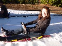 Ashley sledding behind the car